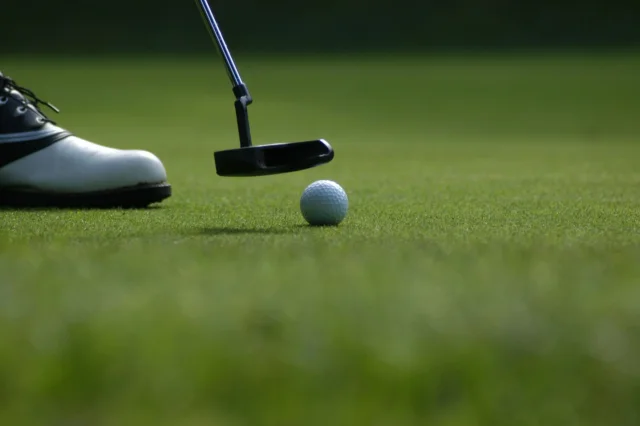 Balle de golf et putter sur green